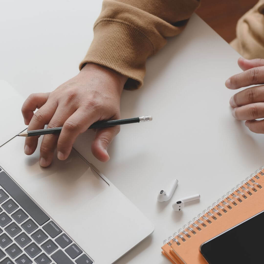 Person Using Air Pad with Airpods on Table